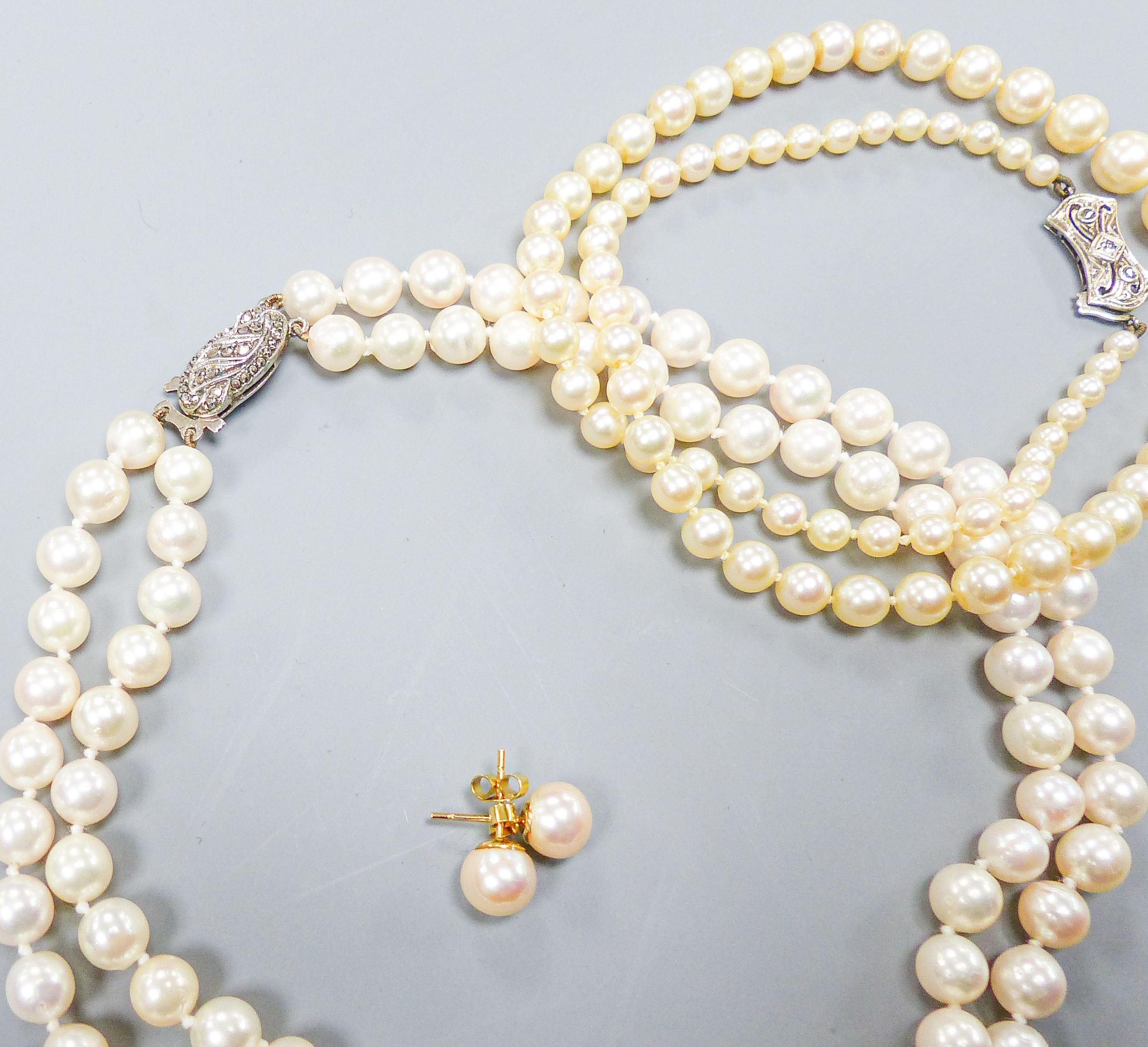 A single strand graduated cultured pearl necklace, with diamond set 9ct clasp, 43cm, a double strand cultured pearl choker necklace, with marcasite set clasp, 32cm and a pair of cultured pearl ear studs.